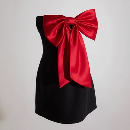 Black dress with a large red bow on a plain background